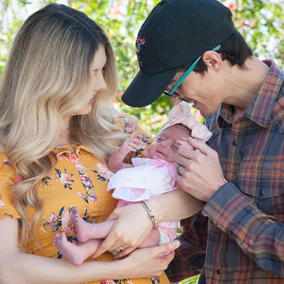 Galluppi family, standing outside in nature with baby daughter