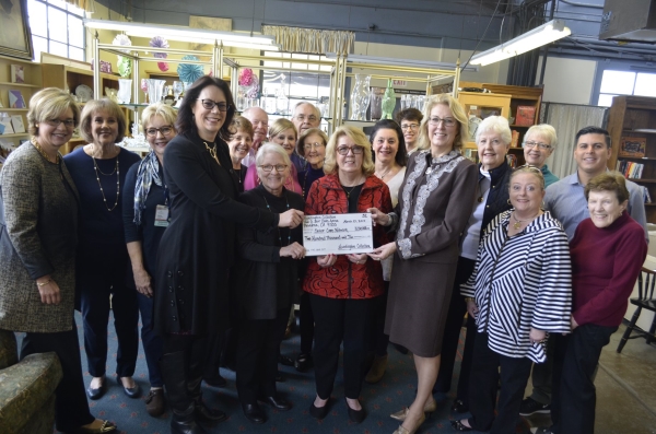 Huntington Hospital volunteers presenting donation check to hospital staff inside thrift store