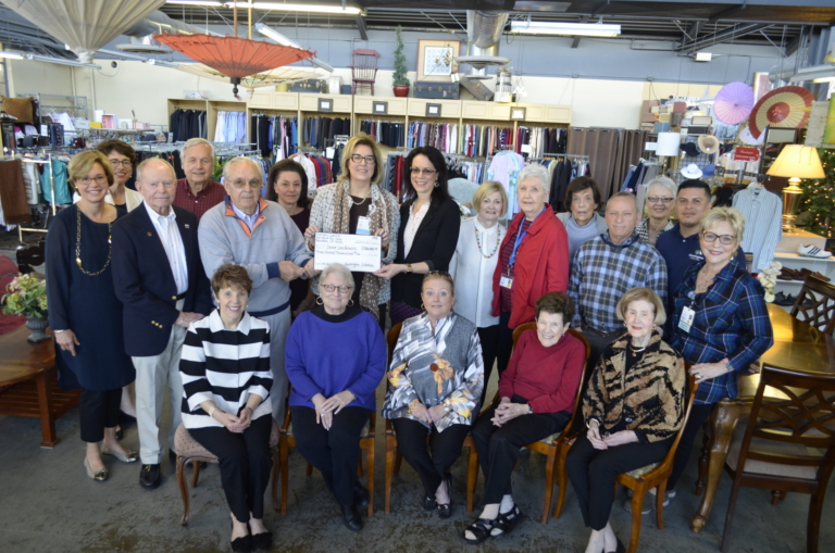 Huntington Hospital volunteers and staff presenting large donation check inside thrift store