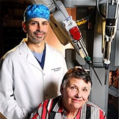 Lisa Perkins and doctor posing in front of robotic machine