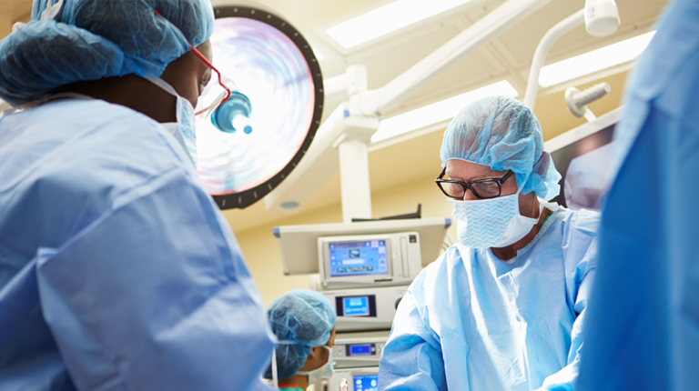 Surgical team in scrubs performing a procedure in operating room