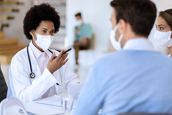 female-doctor-masked-talking-to-patient
