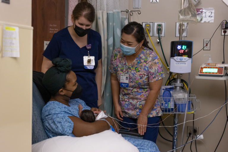 Two NICU nurses caring for mother and newborn in hospital